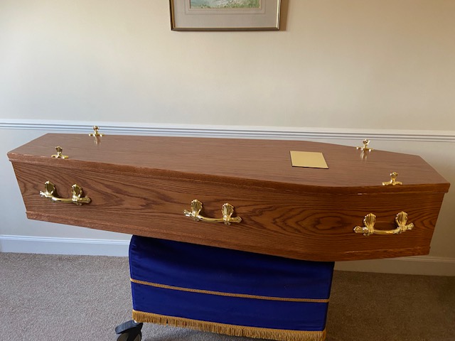 Golden oak cremation coffin with gold bar handles