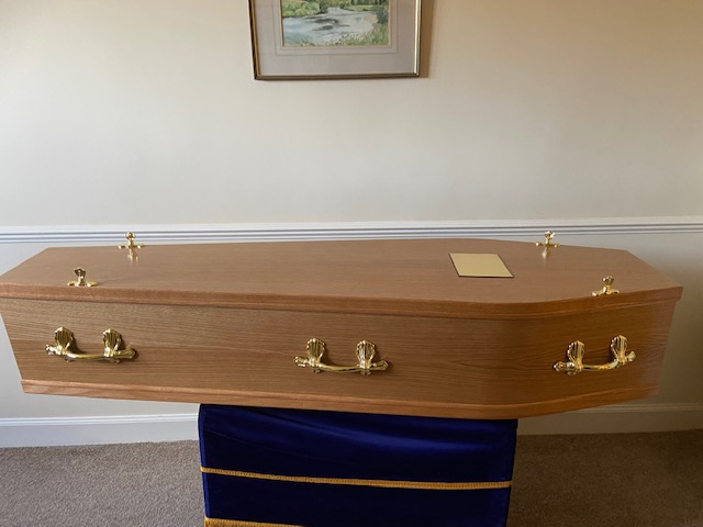 Light oak cremation coffin with gold bar handles